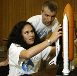 A blind girl explores a space shuttle model during the Science Academy.