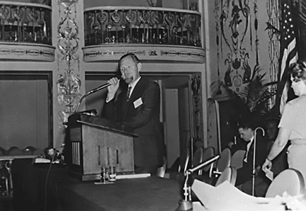 Jacobus tenBroek is pictured at the podium from the right of the stage as he holds the microphone.