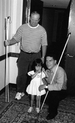 Bob Bracket (left) listens while his daughter Winona talks with cane teacher Eddie Bell.