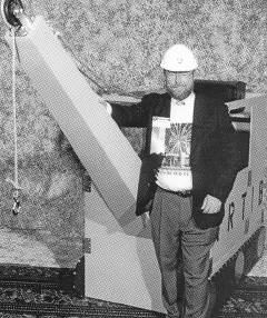 Mr. Cheadle stands beside the crane.