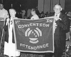 Sharon Maneki and Harry Bond of Maryland display the attendance banner that Frank Coppel from South Carolina has just presented to them.