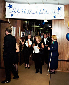 We can see people walkng toward the camera, programs in hand. 