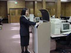 Ann Taylor stands in front of a Braille embosser.