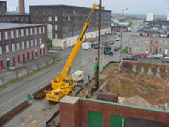A twenty-eight-foot soldier pile being sunk by a pile driver at the end of a fifty-foot boom.