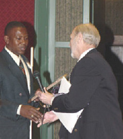 Roland Allen and James Omvig prepare to shake hands.