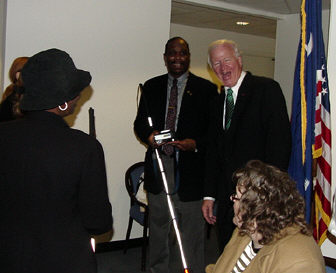Anil Lewis, president of the NFB of Georgia (left center), enjoys a laugh with Senator Saxby Chambliss  while affiliate members look on.