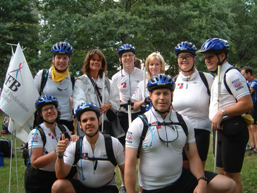 The NFB team poses for a photograph in New York.   Shown are Karen Friedman, holding the NFB flag; Betsy Zaborowski, NFB director of special programs; Michael Gosse; Kristen Cox, director of the Governor's Office for Individuals with Disabilities; Marty Buhrow;and Brian Buhrow.  Kneeling are Holly Mooney, Maurice Peret, and John Brennan, recently appointed chief of staff in the Governor's Office for Individuals with Disabilities.