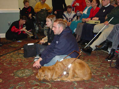 Brian Quintana and Stacy Cervenka sit on the floor at the front of the Columbia Room listening to Dr. Maurer.