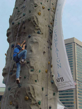 David Venit scales a climbing wall at a Meet-the-Blind-Month celebration at Baltimore's Inner Harbor
