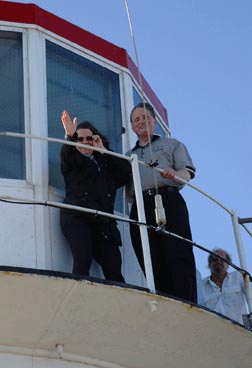 Mary Ellen Jernigan and Marc Maurer receive permission to climb to the top of the lighthouseat Cape Point.   Here they stand on the platform, lighthouse keeper behind them, and enjoy what the keeper called a light breeze