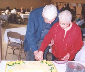 Dick Edlund and Pila Mahoney cut a giant birthday cake.
