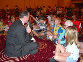 Marc Maurer sitting on floor with kids facing him.