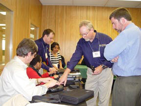 Trainers and Participants looking at access technology products.