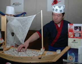 A chef from Matsuri's Teppanyaki arranges sushi at the restaurant booth.
