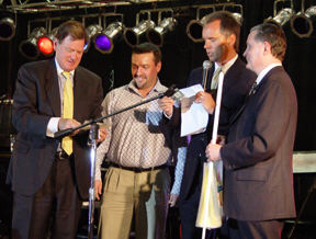 Woody Collins, honorary chair of the first anniversary celebration, inspects the $1000 bill before presentation to Mike Ziegler, while Gerry Sandusky, master of ceremonies, and President Marc Maurer look on