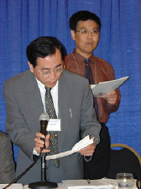 Xie Jing-Ren addresses the board meeting with his translator standing behind him.
