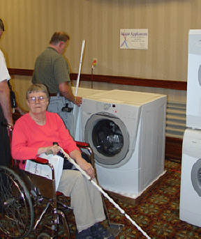 Sarah Sykes examines a Whirlpool front-loading washing machine from her wheelchair.