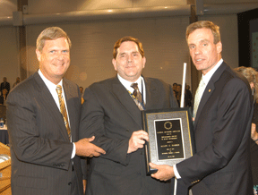 Iowa Governor Thomas Vilsack (left) stands with Allen Harris (center), who is receiving the distinguished service award of the National Governors Association from Virginia Governor Mark Warner.