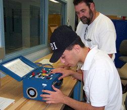Nijat Worley works on the rocket's electronics with NASA electrical technician Jim LaGarde observing his work.