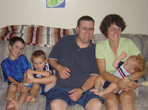 The Wenzel family in their home. Left to right they are Roland, Stephen, Dan, and Jennifer holding Tanner.