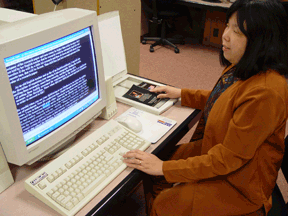 Anne Taylor, IBTC director of access technology, scans a Kernel Book to read using the Kurzweil 1000.