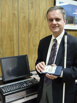 Steve Booth, IBTC access technology specialist, uses a Note Teller to identify currency.