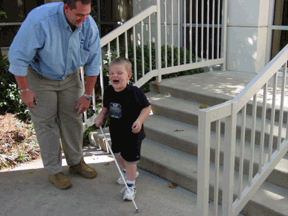 Damen Roberts looks down proudly at his son just after Lance has completed his first independent trip down a flight of steps. Lance is squealing with delight.