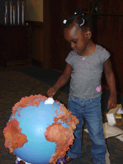 Kayla Harris (MD) examines a tactile globe.
