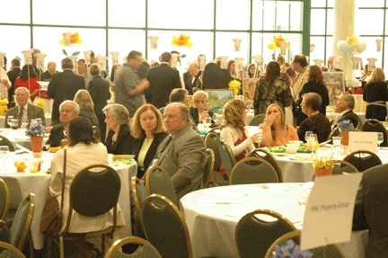 Celebration guests enjoy food and circulate among the silent auction tables.