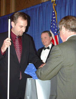 Chris Booher investigates the gift bag presented to him as a 2006 scholarship winner by Ray Kurzweil. To his joy it includes a Kurzweil�National Federation of the Blind Reader.