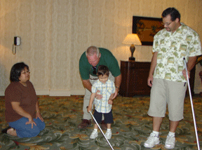 Brain Schetele works with the Valois family to teach four-year-old Tomas how to use his white cane.
