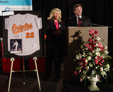 Betsy Satosky displays Baltimore Orioles jersey at the live auction while Marc Steiner prepares to auction it off.