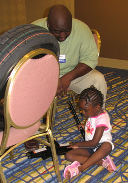 Kevin Harris of Maryland looks on as his four-year-old daughter Kayla examines a crescent wrench.