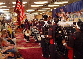 The Atlanta Drum Line performs standing in front of the platform.