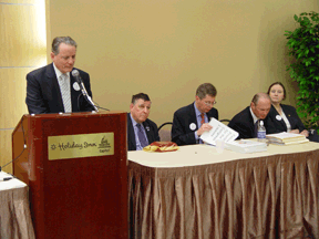 At the head table of the great gathering-in meeting are (left to right) President Maurer at the microphone, Lord Colin Low, John Par&eacute;, James Gashel, and Ann Marie Laney.