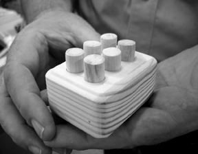 The Braille block is simply an enlarged Braille cell made of wood that has been drilled with two vertical rows of three holes. The six dots are short lengths of dowel rod that fit snugly into the holes. The finished product may look simple, but making it requires accurate measuring and the skilled use of six different power tools.