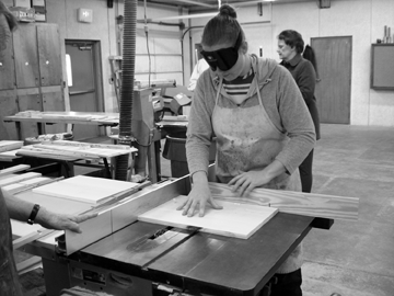 Serena Olsen prepares to cut a partition for her project using a circular table saw. After painstakingly measuring and cutting the partitions for her shoe organizer, she will fit them together. They are so accurately made that no nails or screws are required to hold them in place.