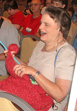 Barbara Pierce listens to the convention session while knitting.