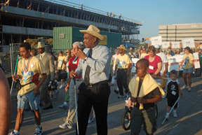 NFB of Georgia President Anil Lewis and his son Amari urge the crowd on with chants and slogans. Here Anil Lewis speaks into a portable microphone with a crowd of Federationists not far behind him.