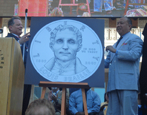 Marc Maurer (left) and Ed Moy, director of the U.S. Mint (right) unveil the obverse of the newly designed Louis Braille Bicentennial Silver Dollar.