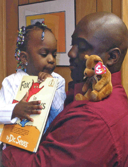 Kevin Harris holds his daughter Kayla and her Beanie Baby reading pal as they prepare to read a book together.