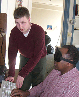 Steve Decker instructs Abdirisak Osman at a computer.