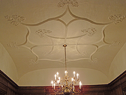Pictured here is part of the molded plaster ceiling and the original brass chandelier in the entry area of the mansion. Many of the rooms are enhanced by such decoration.