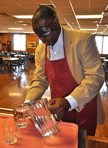 A man under sleepshades pours water. 