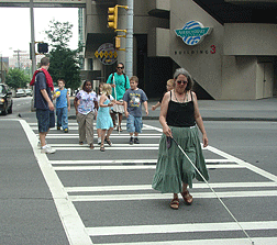 Elizabeth Rousseau Rooney (Oregon) leads NFB campers through a crosswalk.