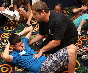 Joe Shaw instructs a teenager in the fine art of doing crunches correctly.