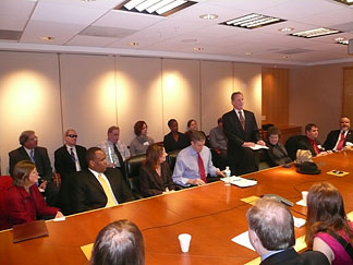 At the table, pictured left to right are Lynnae Ruttledge, commissioner of the Rehabilitation Services Administration; Kareem Dale, special assistant to the president for disability policy; Dr. Alexa Posny, assistant secretary for the Office of Special Education and Rehabilitative Services; Arne Duncan, U.S. secretary of education; President Maurer, standing and reading from a Braille document; Mrs. Patricia Maurer, NFB first lady; Chris Danielsen, NFB director of Public Relations; and Kevan Worley, president of the National Association of Blind Merchants.