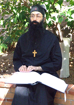 Father Ephraim reads Braille in his garden.