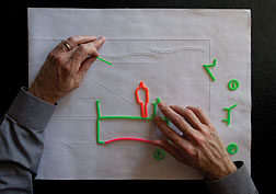 Downey uses wax tools called Wikki Stix to sketch on embossed plans. Photo by Don Fogg