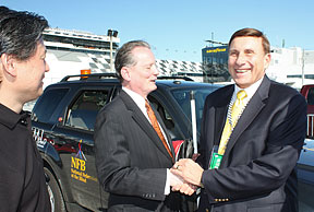 Virginia Tech Professor Dennis Hong, NFB President Marc Maurer, and Florida Congressman John Mica stand on the track.